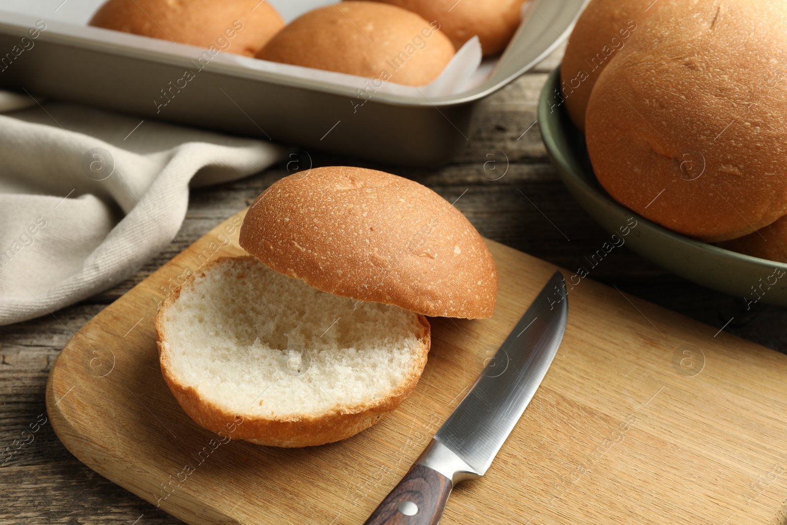 Photo of Fresh tasty buns and knife on table, closeup