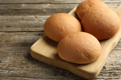 Fresh tasty buns on wooden table, closeup