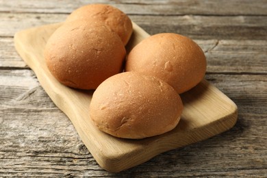 Fresh tasty buns on wooden table, closeup