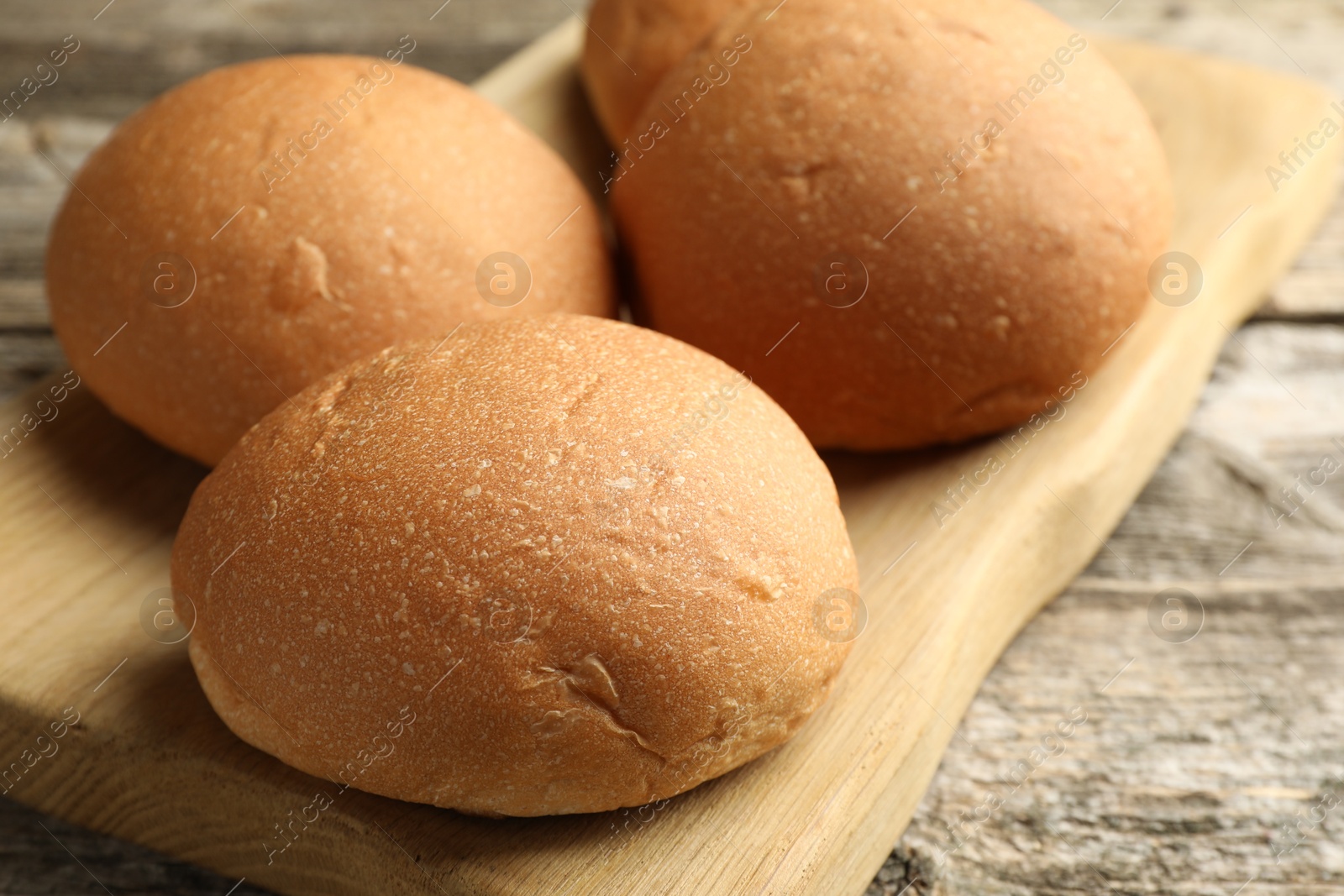 Photo of Fresh tasty buns on wooden table, closeup