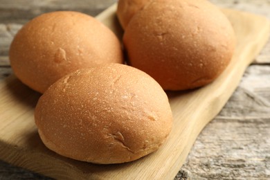 Fresh tasty buns on wooden table, closeup