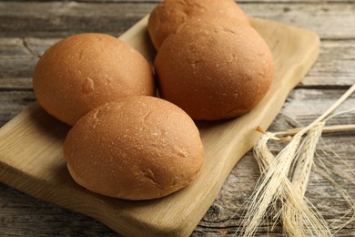 Photo of Fresh tasty buns and spikes on wooden table, closeup