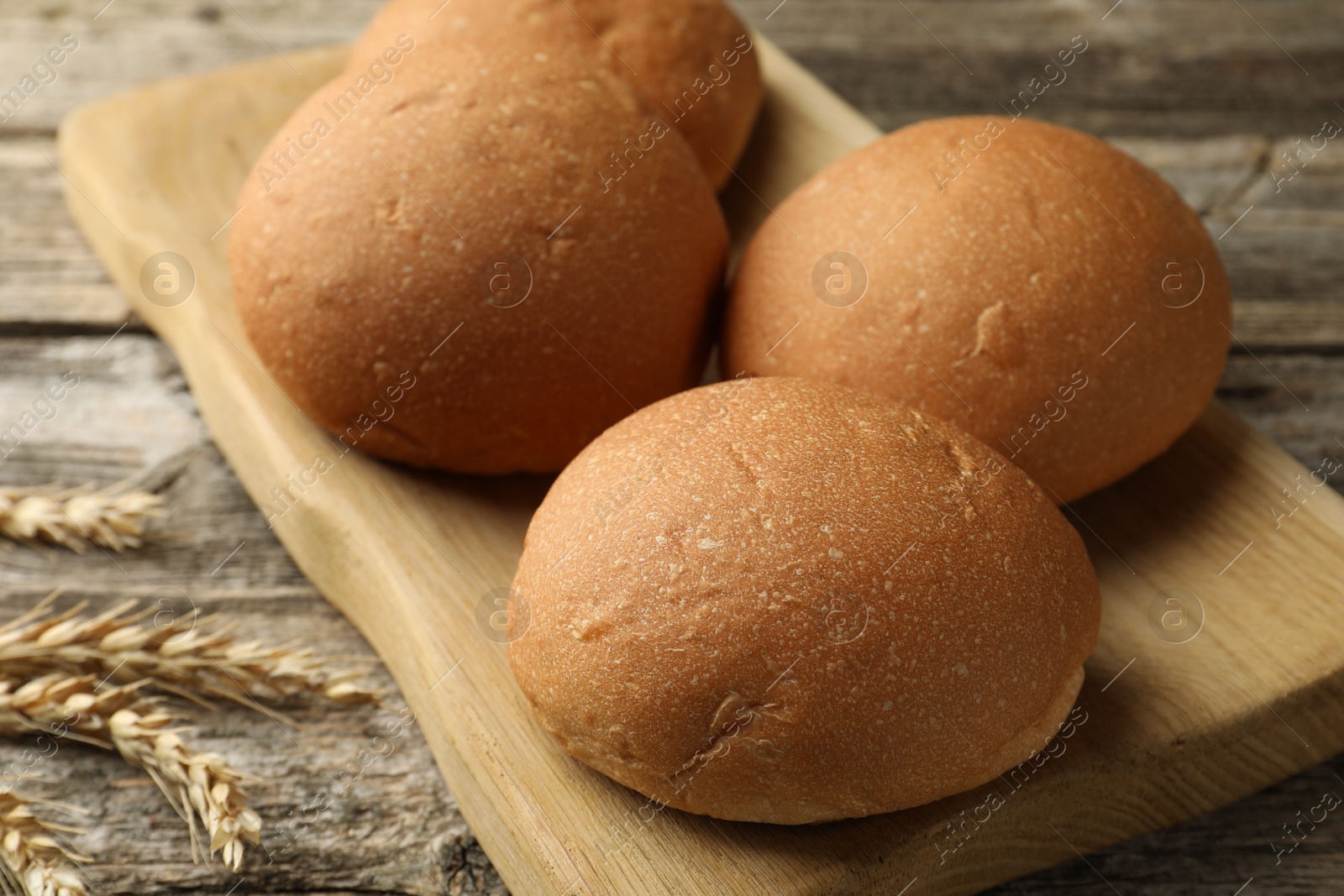 Photo of Fresh tasty buns and spikes on wooden table, closeup