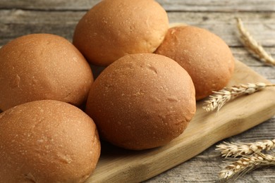 Fresh tasty buns and spikes on wooden table, closeup