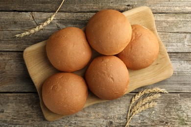 Fresh tasty buns and spikes on wooden table, top view