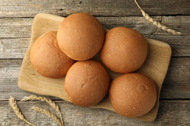 Photo of Fresh tasty buns and spikes on wooden table, top view