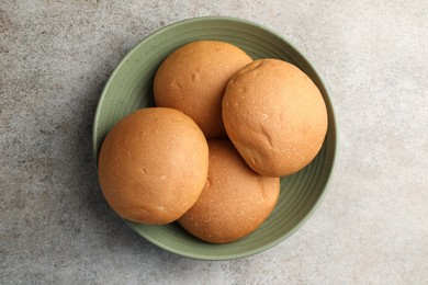 Photo of Fresh tasty buns on grey table, top view