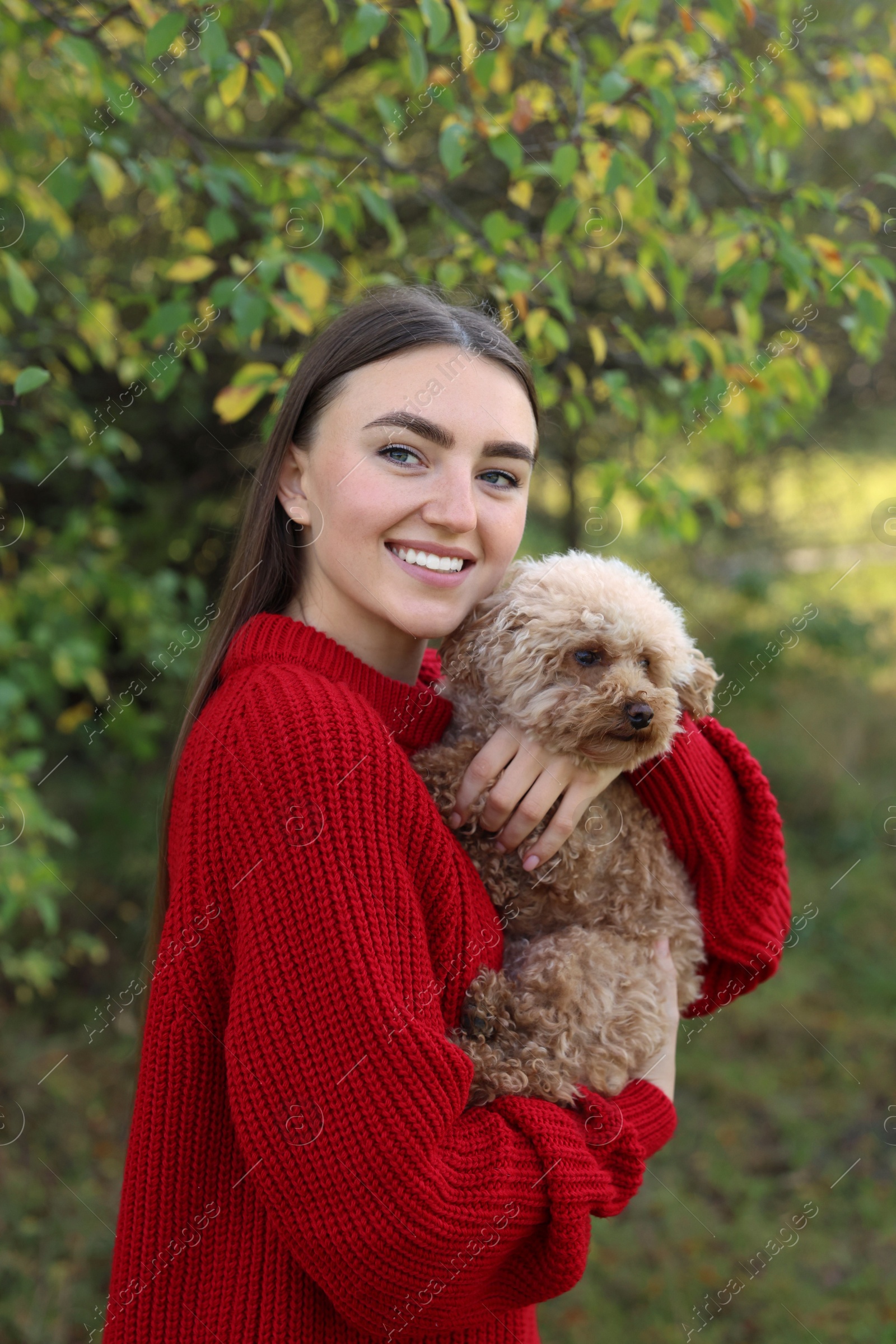 Photo of Smiling woman with cute dog in autumn park