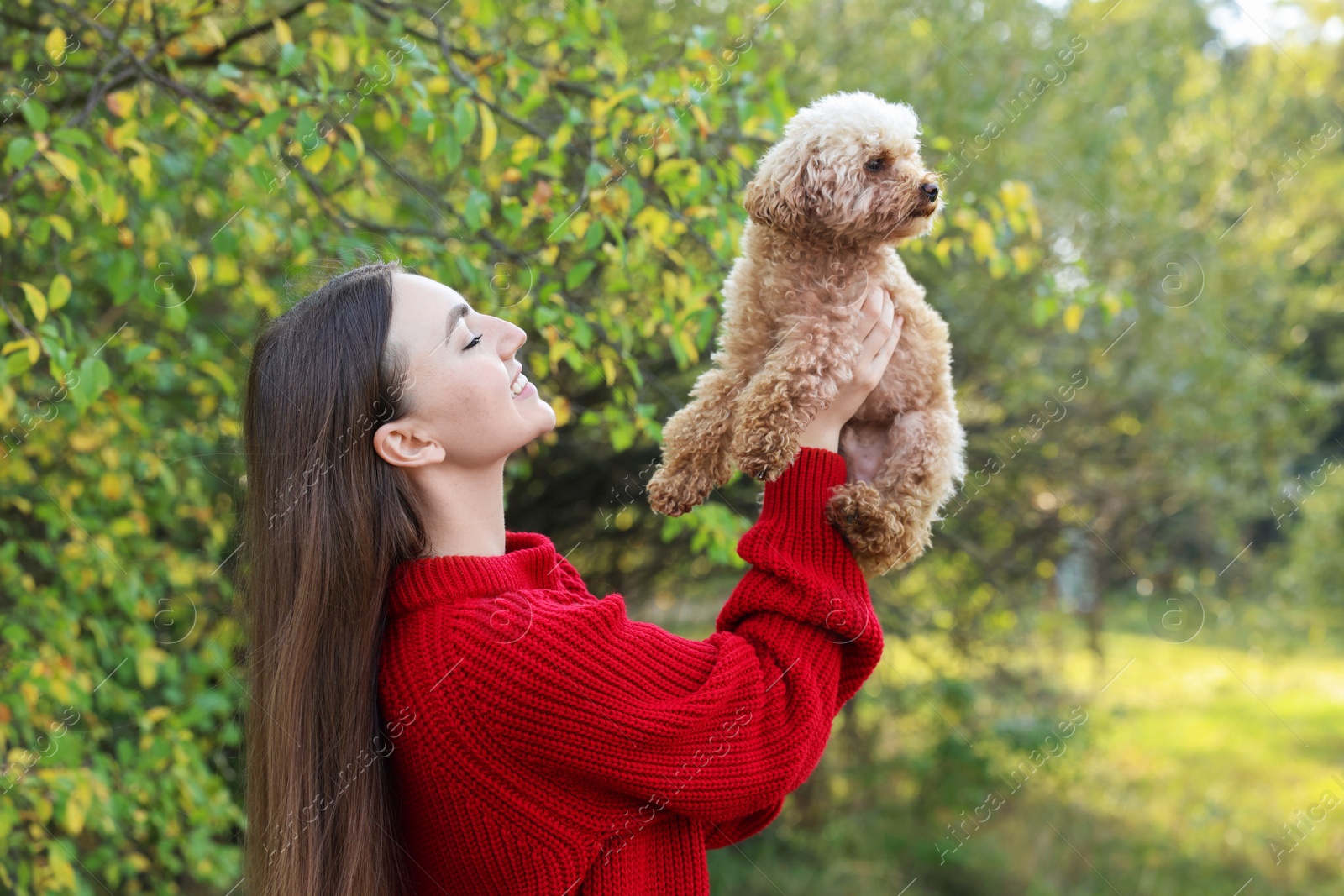 Photo of Smiling woman with cute dog in autumn park