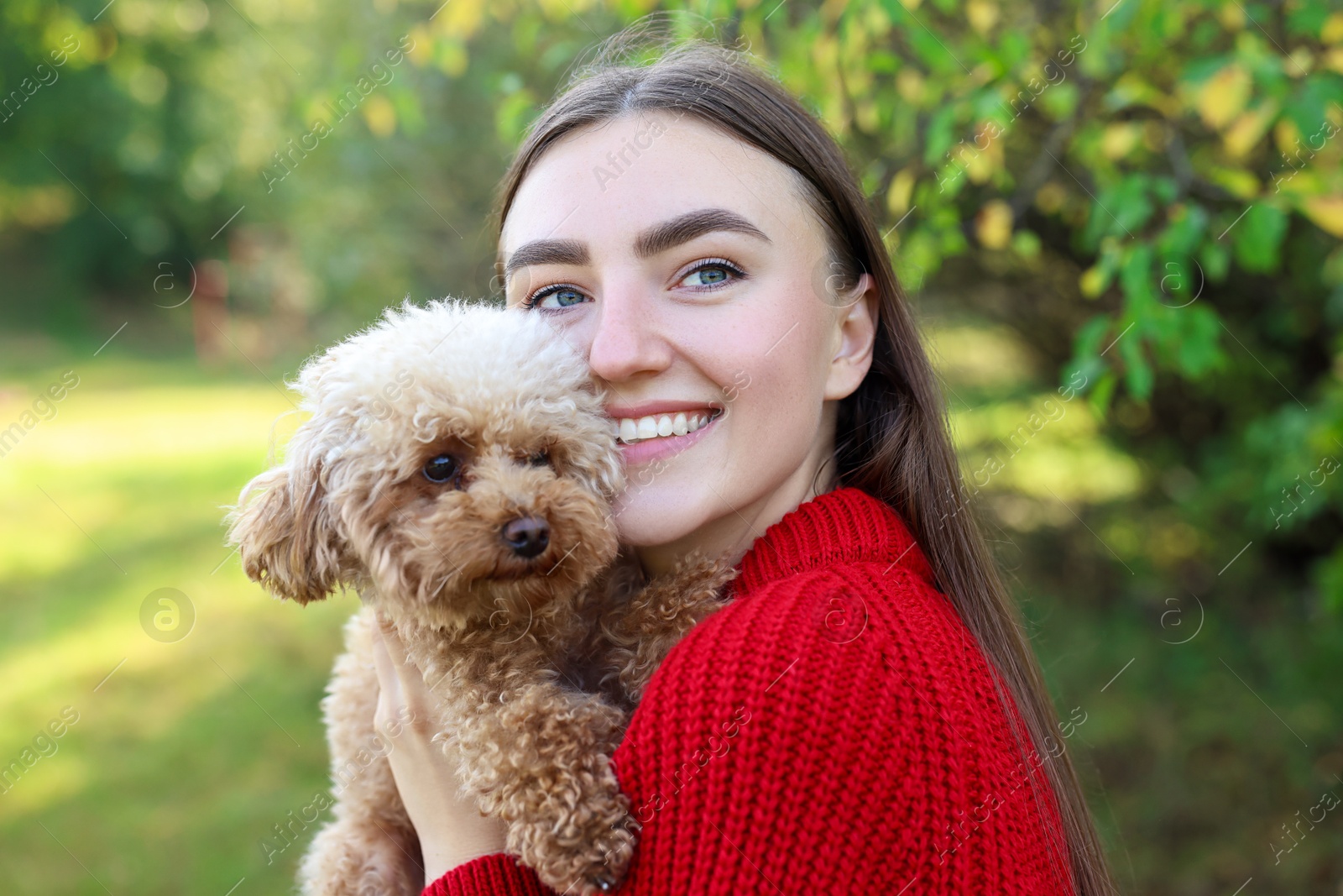 Photo of Smiling woman with cute dog in autumn park