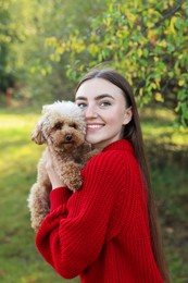 Smiling woman with cute dog in autumn park