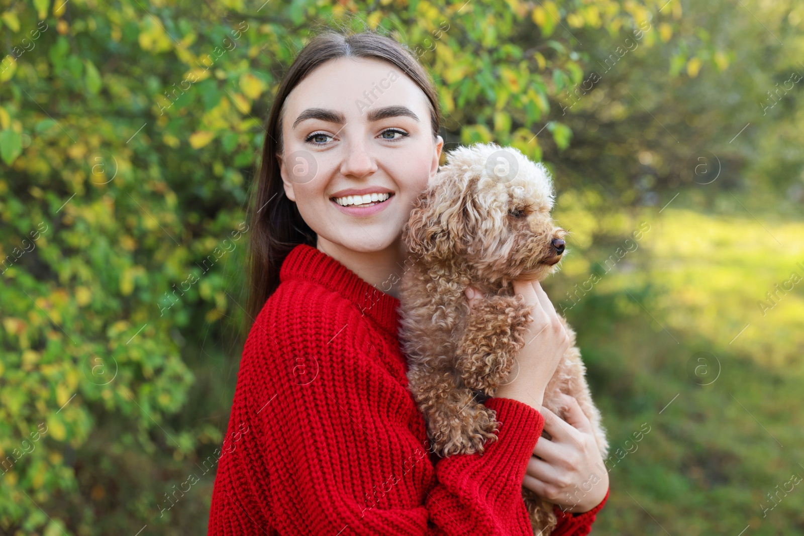 Photo of Smiling woman with cute dog in autumn park