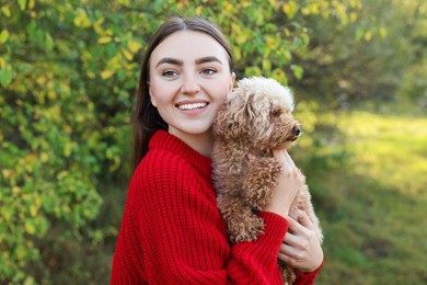 Photo of Smiling woman with cute dog in autumn park