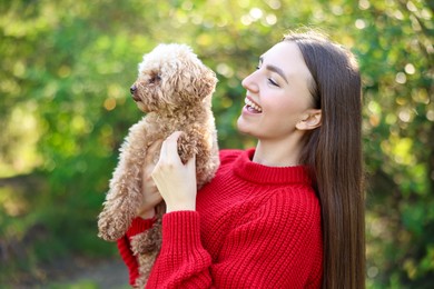 Photo of Smiling woman with cute dog in autumn park