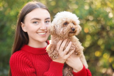 Photo of Smiling woman with cute dog in autumn park