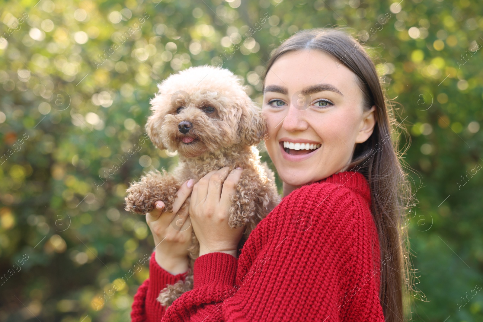 Photo of Smiling woman with cute dog in autumn park