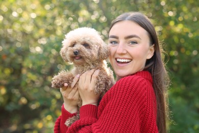 Photo of Smiling woman with cute dog in autumn park