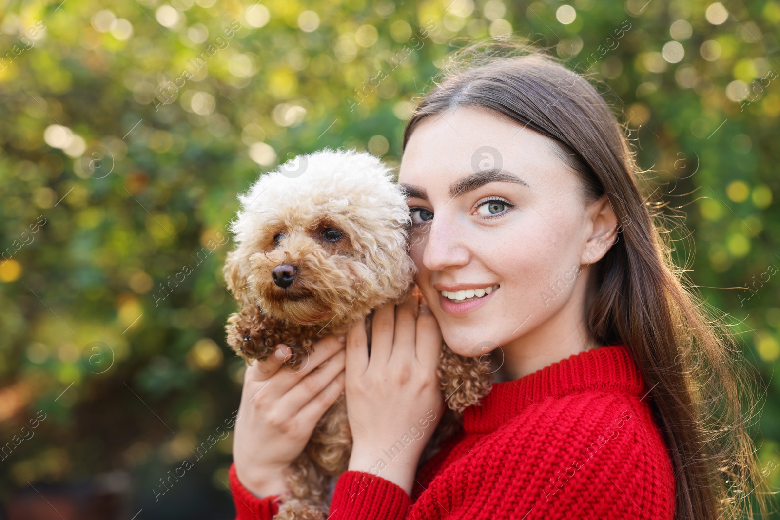 Photo of Smiling woman with cute dog in autumn park