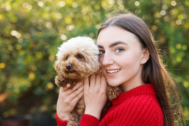 Photo of Smiling woman with cute dog in autumn park