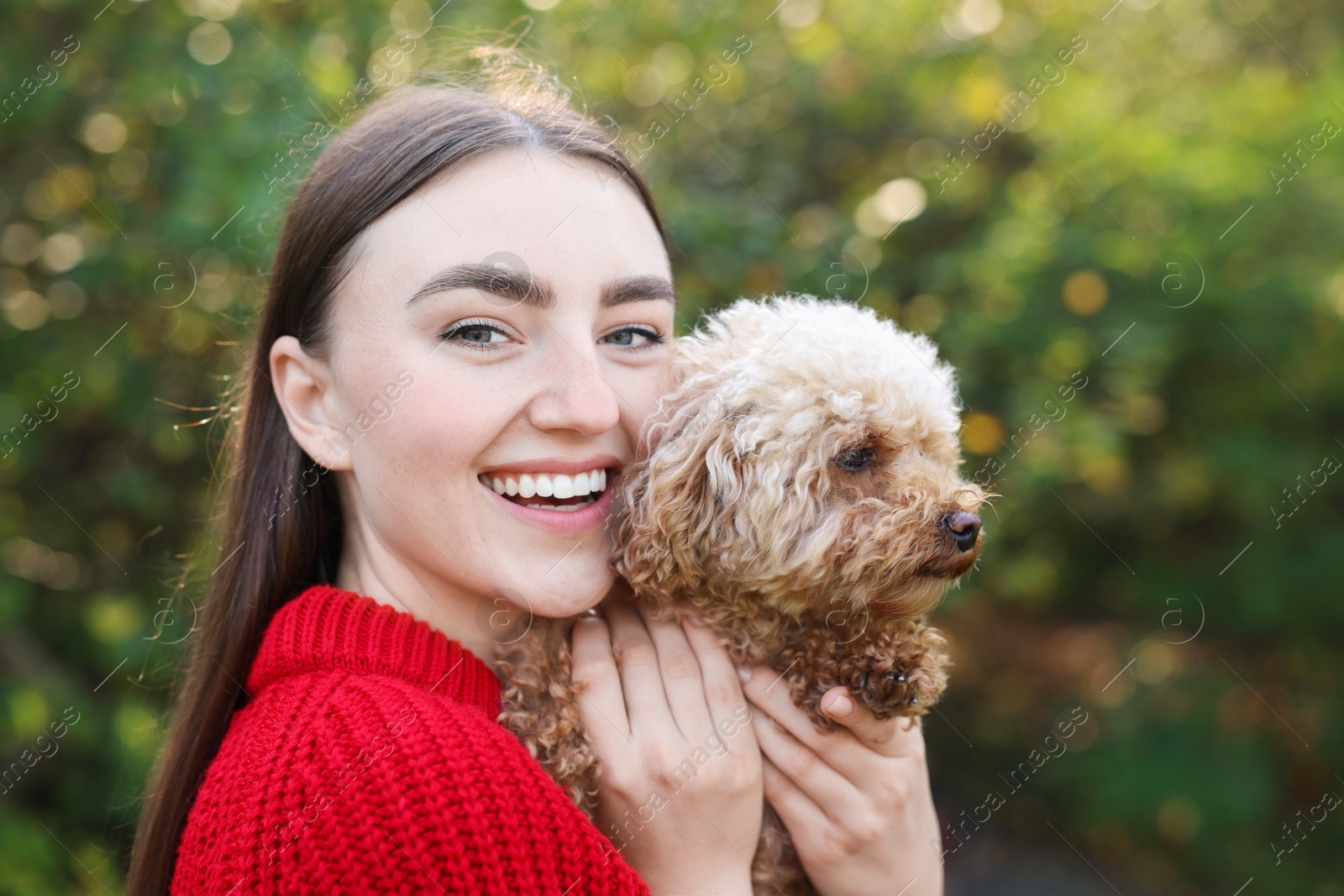 Photo of Smiling woman with cute dog in autumn park