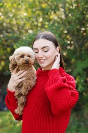 Portrait of woman with cute dog outdoors