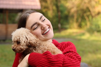 Smiling woman with cute dog in autumn park. Space for text