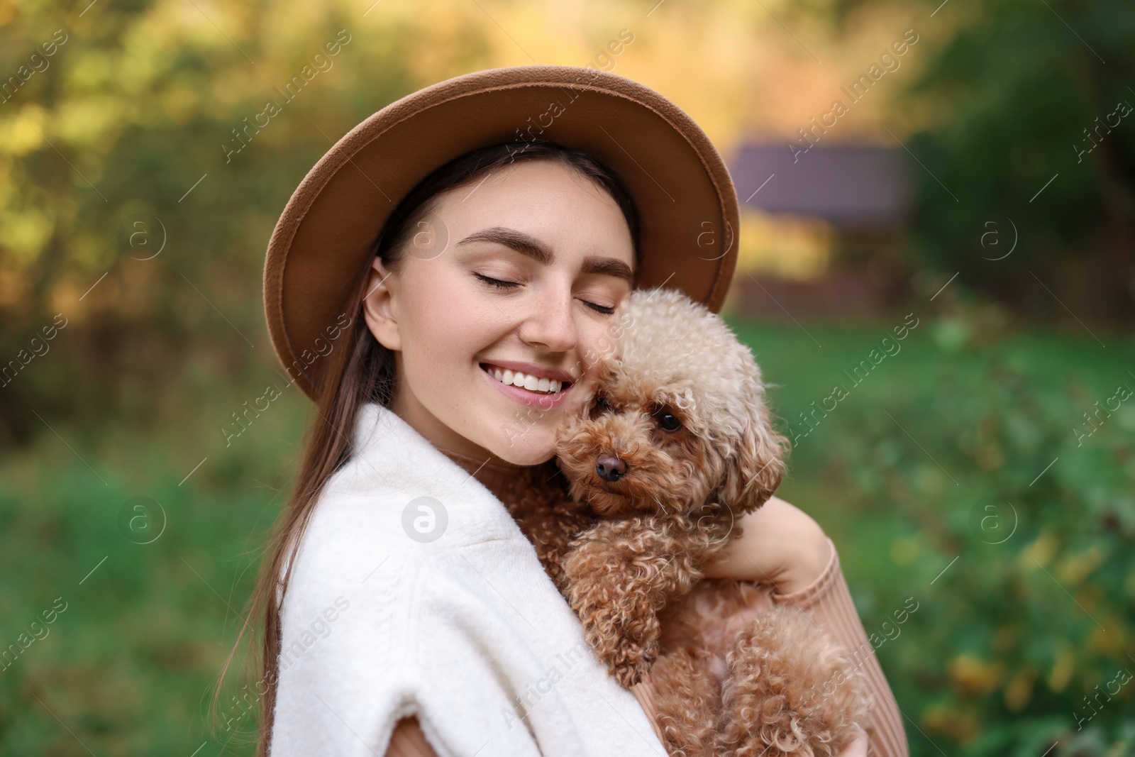 Photo of Portrait of smiling woman with cute dog outdoors