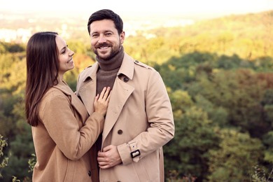 Beautiful couple spending time together outdoors on autumn day, space for text