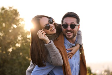 Photo of Beautiful couple having fun together in autumn park, low angle view