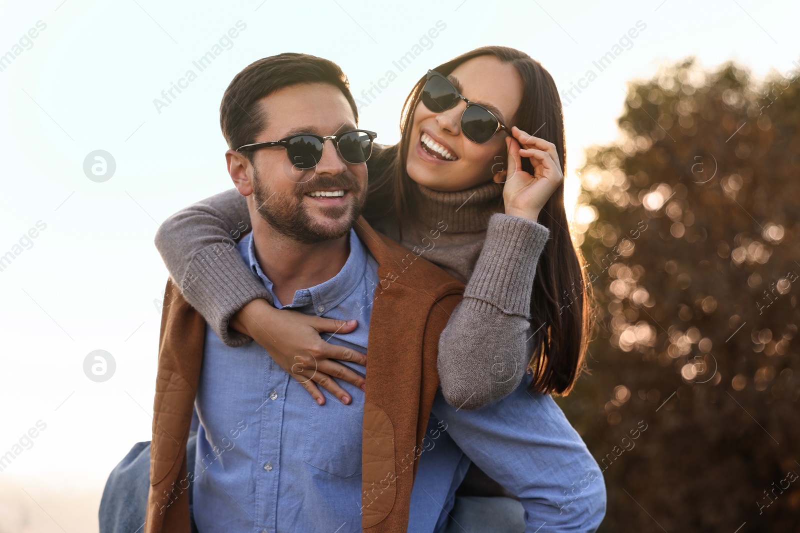 Photo of Beautiful couple having fun together in autumn park, low angle view