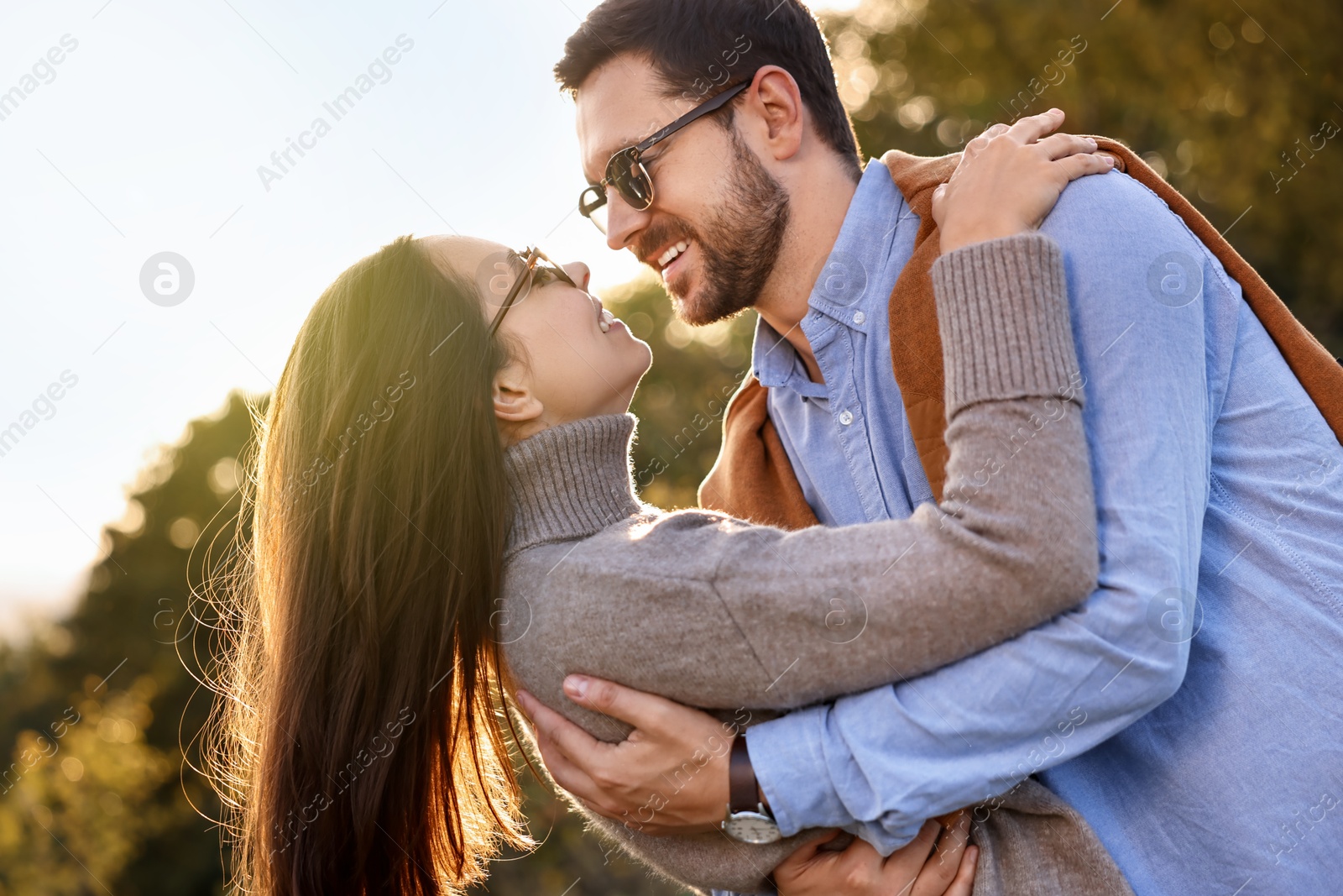 Photo of Beautiful couple having fun together in autumn park, low angle view