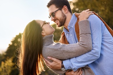 Beautiful couple having fun together in autumn park, low angle view