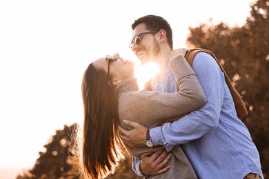 Photo of Beautiful couple having fun together in autumn park, low angle view