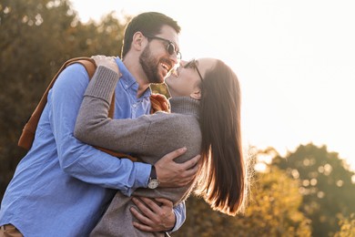 Photo of Beautiful couple having fun together in autumn park, low angle view