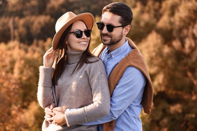 Beautiful happy couple in sunglasses outdoors on autumn day