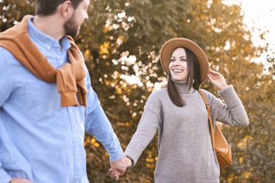 Photo of Beautiful couple walking together in park on autumn day, selective focus