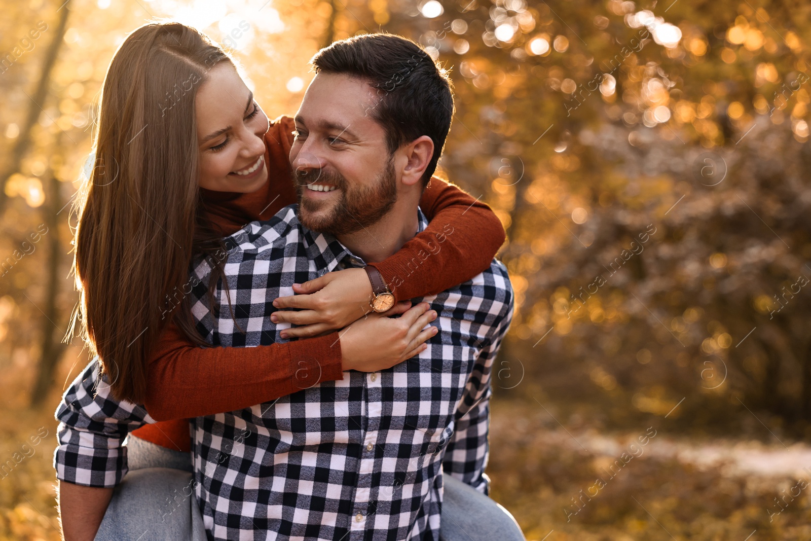 Photo of Beautiful couple having fun together in park on autumn day, space for text