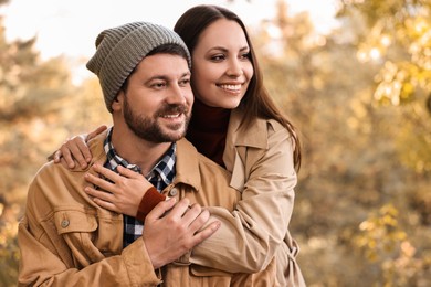 Photo of Beautiful happy couple hugging outdoors on autumn day