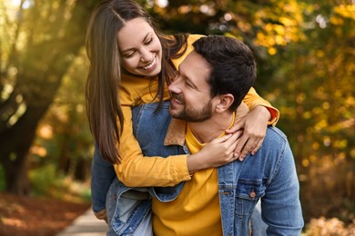 Beautiful couple spending time together in park on autumn day