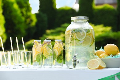 Lemonade stand with refreshing drink and fresh fruits in park