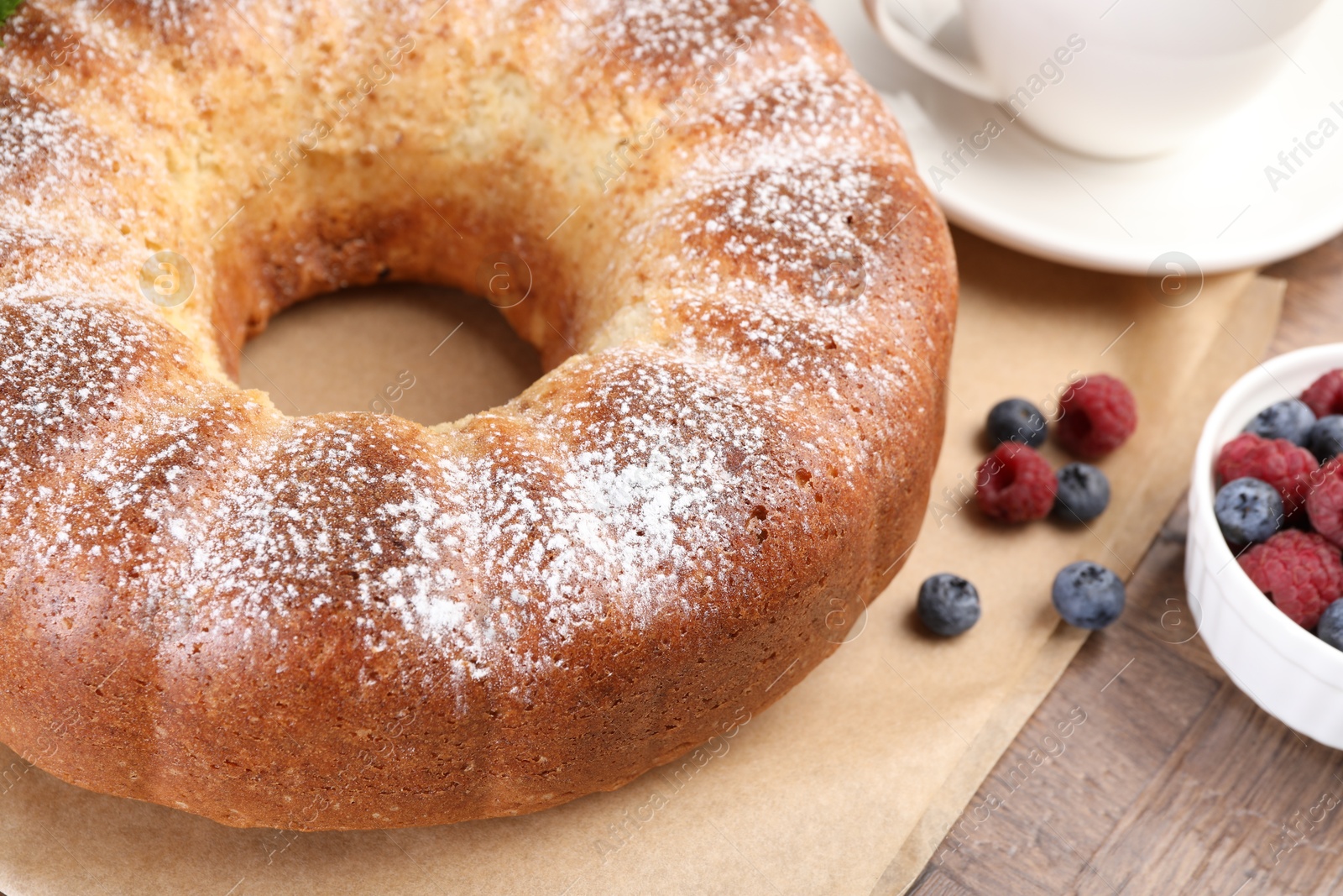 Photo of Freshly baked sponge cake and berries on wooden table, closeup