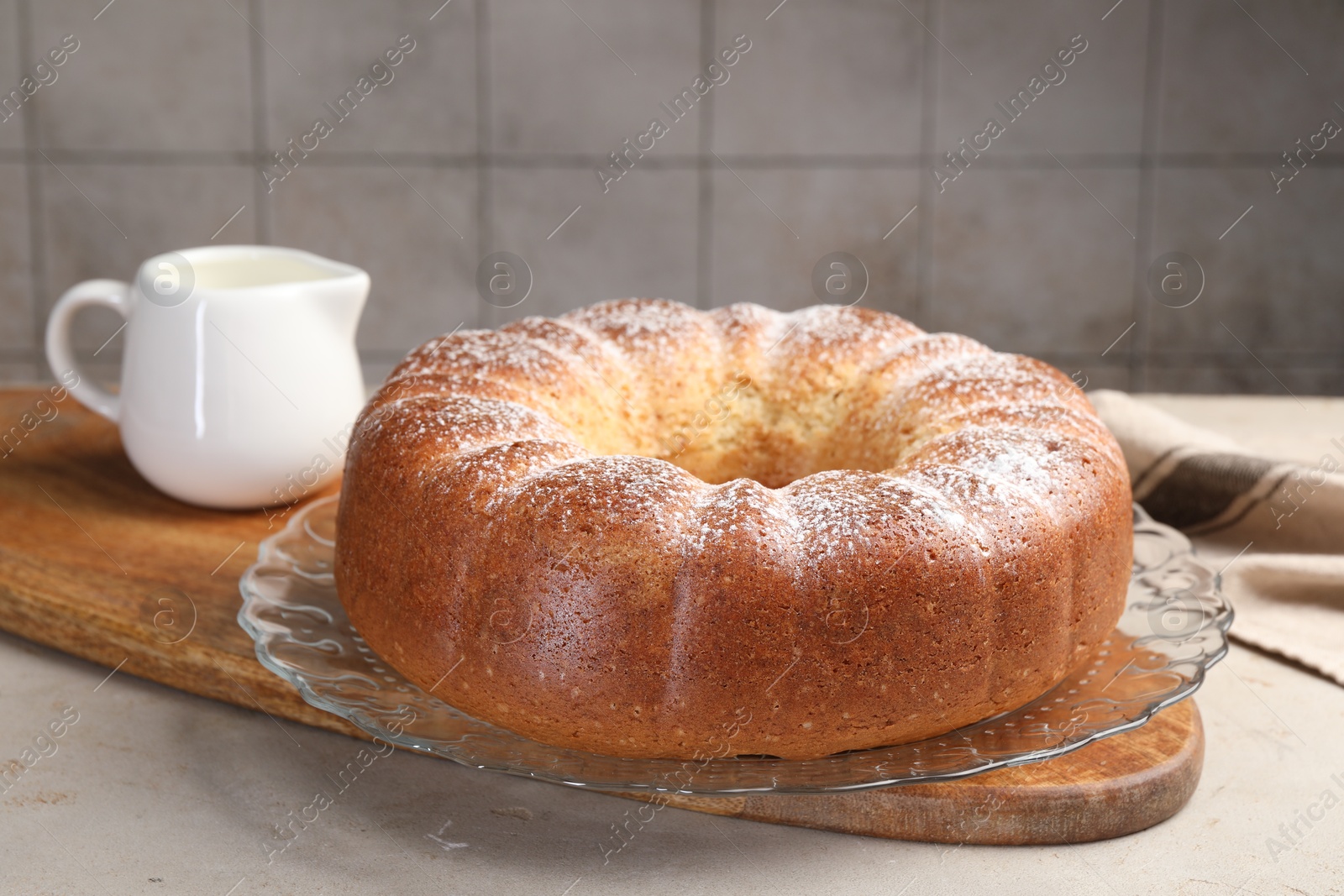 Photo of Freshly baked sponge cake and milk on light grey table, closeup