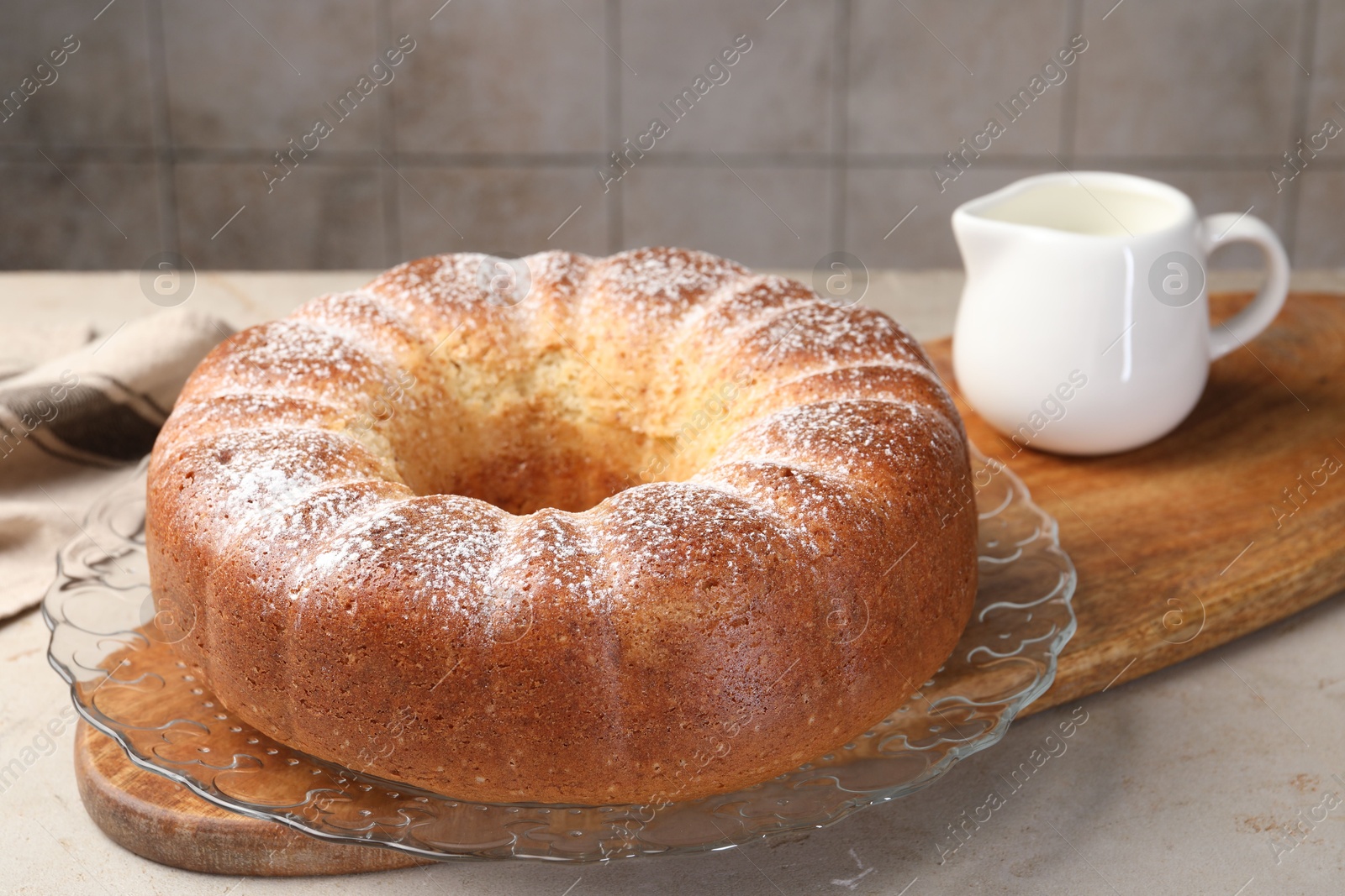 Photo of Freshly baked sponge cake and milk on light grey table, closeup