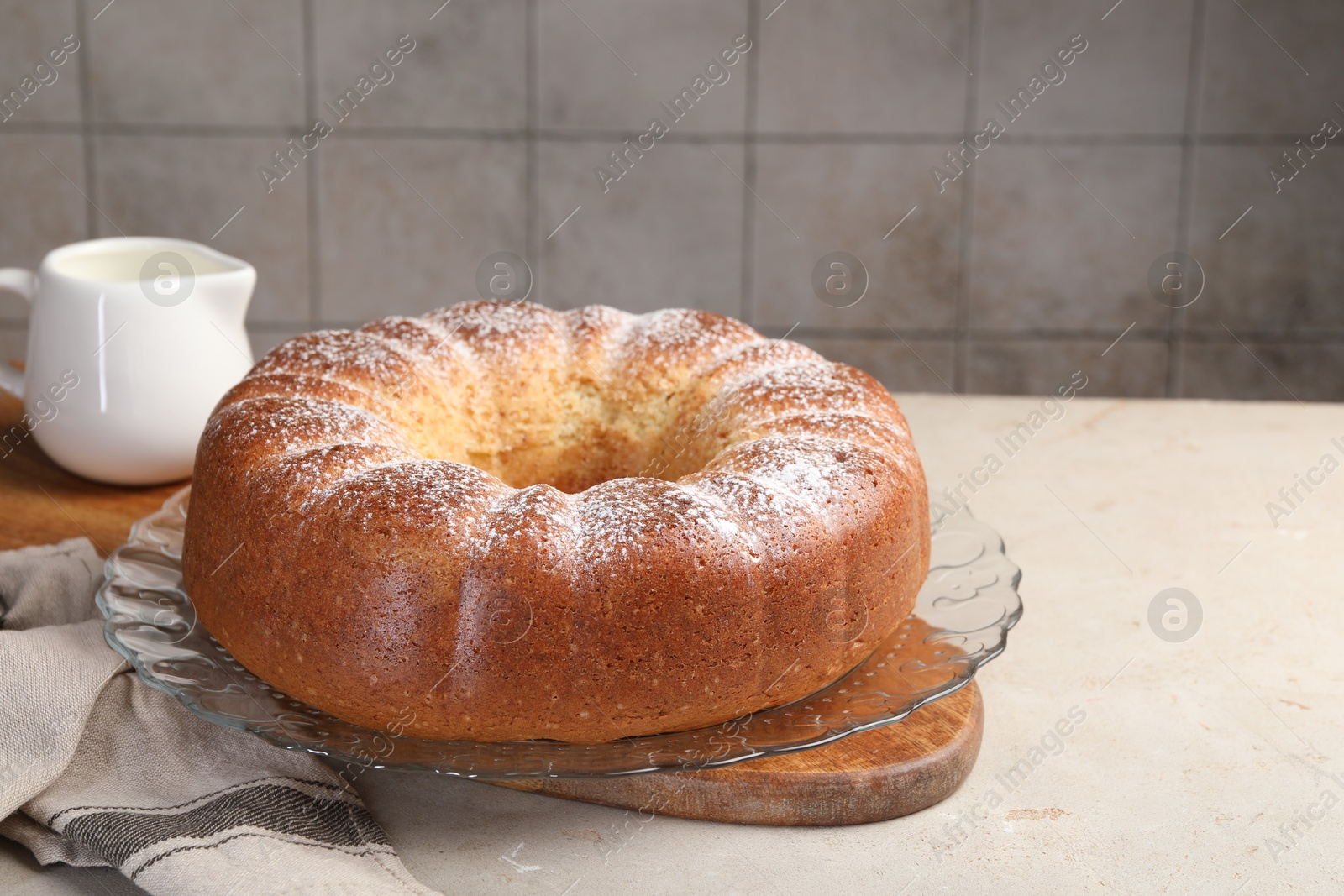 Photo of Freshly baked sponge cake and milk on light grey table, closeup