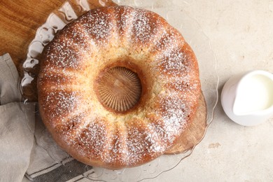 Photo of Freshly baked sponge cake and milk on light grey table, top view