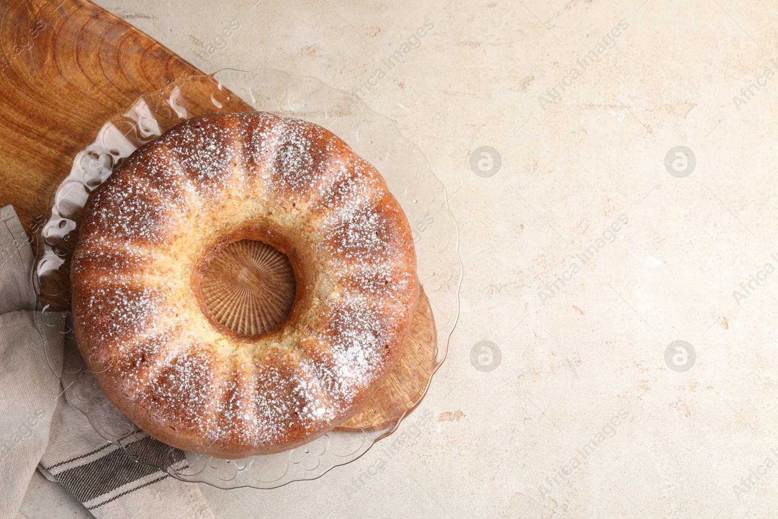 Photo of Freshly baked sponge cake on light grey table, top view. Space for text