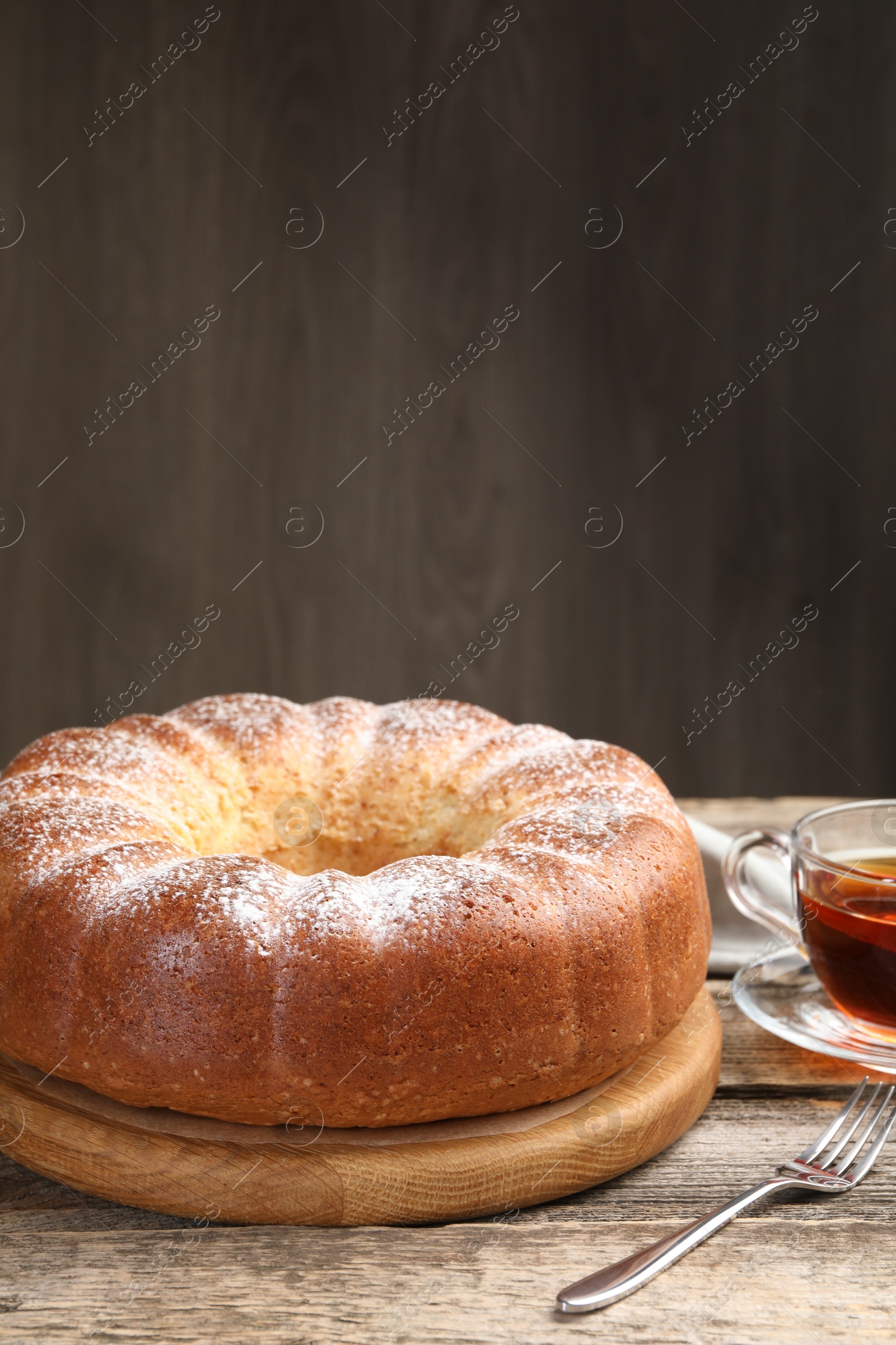 Photo of Freshly baked sponge cake and tea on wooden table