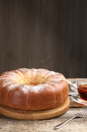 Photo of Freshly baked sponge cake and tea on wooden table