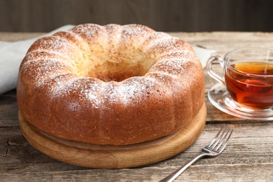 Freshly baked sponge cake and tea on wooden table, closeup