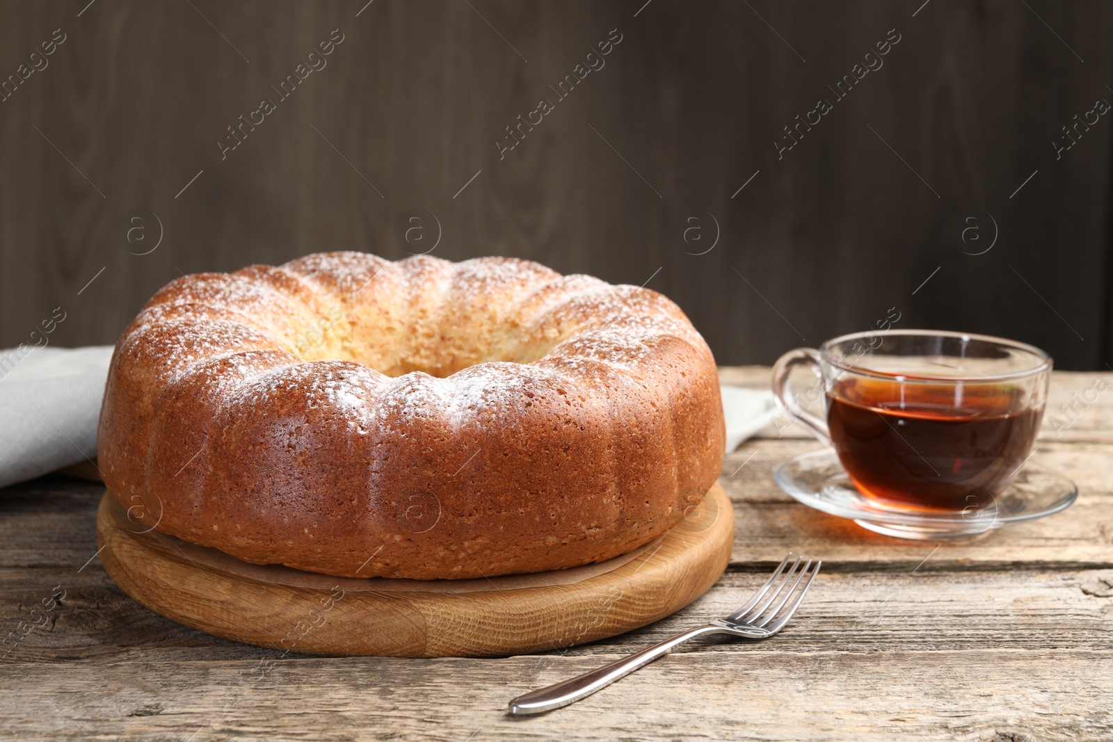 Photo of Freshly baked sponge cake and tea on wooden table